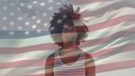Animation-of-waving-flag-of-america-over-biracial-man-standing-against-ocean-at-beach