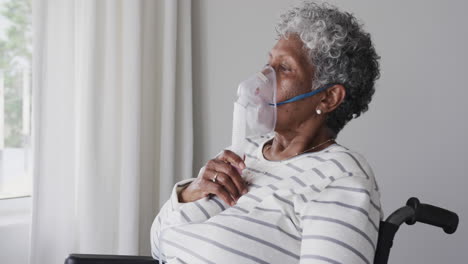 Ältere-Afroamerikanische-Frau-Im-Rollstuhl-Mit-Sauerstoffmaske,-Kopierraum,-Zeitlupe