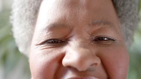 Portrait-close-up-of-eyes-of-happy-senior-african-american-woman-smiling-in-sunny-room,-slow-motion