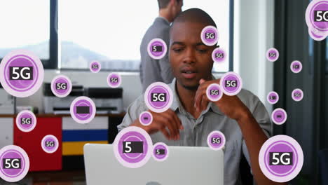 Animation-of-5g-text-and-symbols-in-circles,-african-american-man-tired-after-working-on-laptop