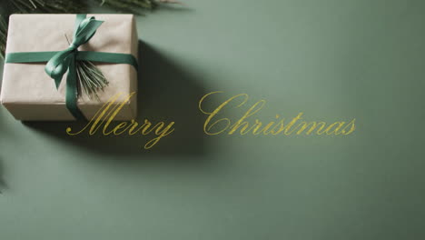 Animation-of-merry-christmas-text-and-christmas-gift-on-green-background