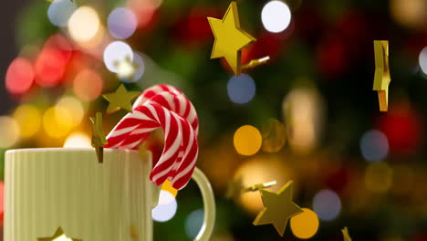 Animation-of-gold-stars-christmas-decorations-over-mug-with-candy-canes-background