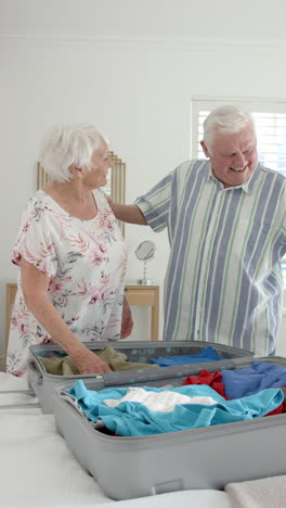 Senior-Caucasian-couple-packing-a-suitcase-in-a-bright-home