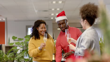 Casual-diverse-businesspeople-drinking-champagne-at-christmas-in-office,-slow-motion