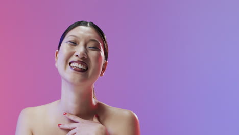 Asian-woman-with-black-hair-and-make-up-smiling-to-camera,-copy-space,-slow-motion