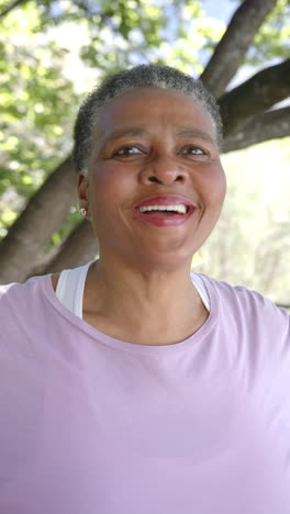 Vertical-video-portrait-of-happy-senior-african-american-woman-in-sunny-nature,-slow-motion