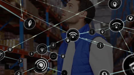 Animation-of-connected-icons-over-caucasian-man-checking-inventory-in-warehouse