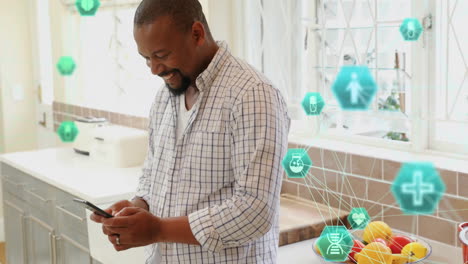 Animation-of-connected-icons-globes-over-smiling-african-american-man-using-smartphone-at-home