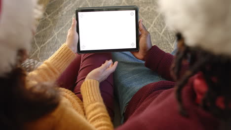 Overhead-diverse-couple-making-christmas-video-call-on-tablet,-copy-space-screen,-slow-motion