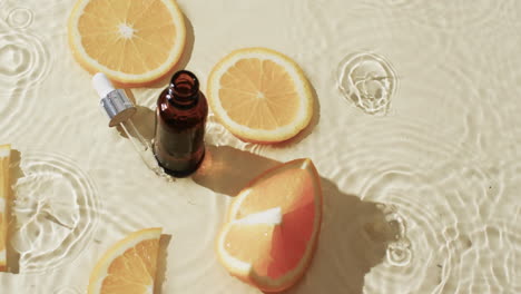 Video-Einer-Kosmetikflasche,-Pipette,-Orangenscheiben-In-Wasser-Mit-Kopierraum-Auf-Gelbem-Hintergrund