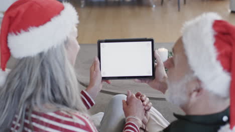 Middle-aged-caucasian-couple-with-tablet-with-blank-screen-at-christmas-at-home,-slow-motion