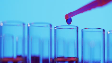 Video-of-laboratory-pipette-and-test-tubes-with-copy-space-on-blue-background