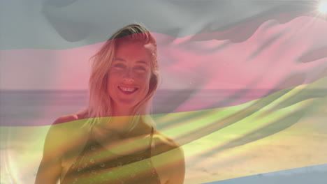 Animation-Einer-Wehenden-Flagge-Deutschlands-über-Einer-Lächelnden-Kaukasischen-Frau,-Die-Am-Strand-Vor-Dem-Meer-Steht