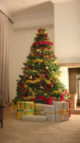 Video-Vertical-De-Regalos-Bajo-Un-árbol-De-Navidad-Decorado-En-La-Sala-De-Estar,-Cámara-Lenta