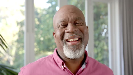 Porträt-Eines-Glücklichen-älteren-Afroamerikanischen-Mannes,-Der-Im-Sonnigen-Wohnzimmer-Lacht,-Zeitlupe