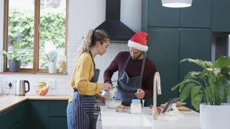 Happy-diverse-couple-baking-christmas-cookies-in-kitchen-at-home,-in-slow-motion