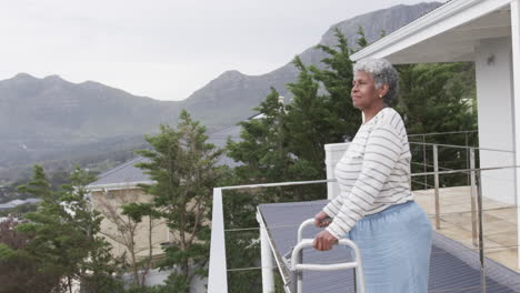 Ältere-Afroamerikanische-Frau-Mit-Gehhilfe-Auf-Dem-Balkon,-Kopierraum,-Zeitlupe
