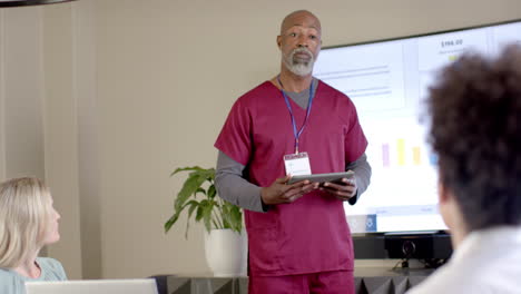 African-american-male-doctor-using-tablet-in-meeting-room-with-copy-space,-slow-motion