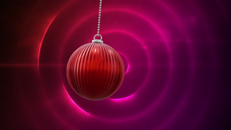 Animation-of-christmas-red-bauble-and-pink-and-red-glowing-circles-background