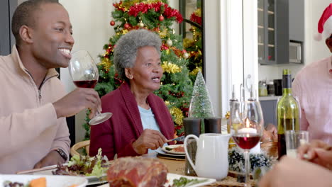 Happy-african-american-father-and-grandmother-at-multi-generation-family-christmas-dinner-table