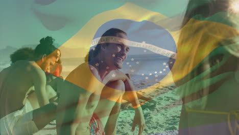Animation-of-flag-of-brazil-waving-over-diverse-friends-discussing-while-sitting-on-beach