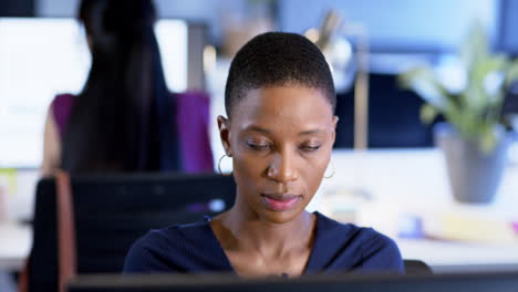Portrait-of-african-american-businesswoman-using-computer-in-office,-slow-motion,-copy-space