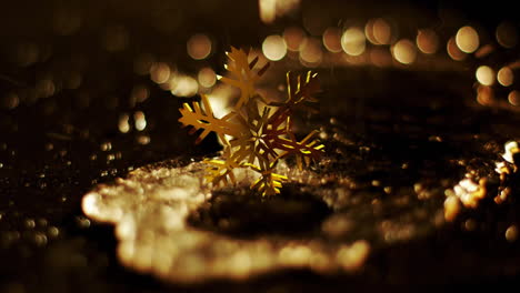 Animation-of-golden-snowflake-rotating-over-liquid-falling-on-ground