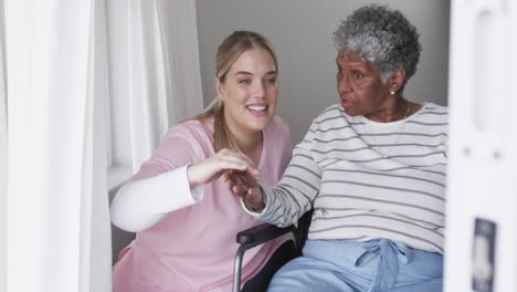 Smiling-caucasian-nurse-talking-with-senior-african-american-woman-patient,-slow-motion