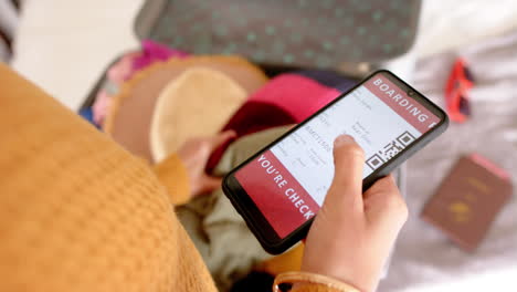 Mittelteil-Einer-Kaukasischen-Frau-Mit-Smartphone-Und-Kofferpacken-Zu-Hause,-Kopierraum,-Zeitlupe