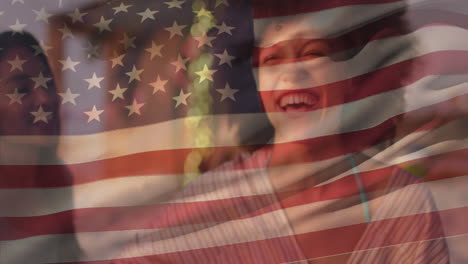 Animation-of-waving-national-flag-of-america-over-smiling-diverse-female-friends