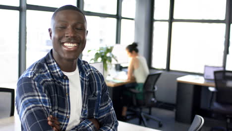 Portrait-of-smiling-african-american-businessman-in-office,-slow-motion,-copy-space