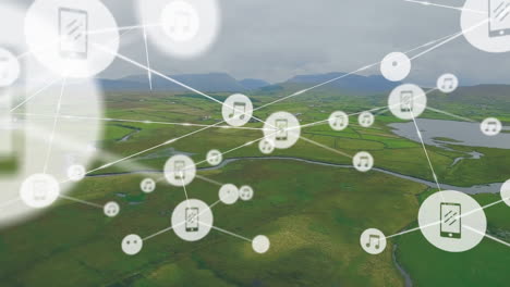 Animation-of-connected-icons-over-aerial-view-of-water-stream-on-green-land-against-cloudy-sky
