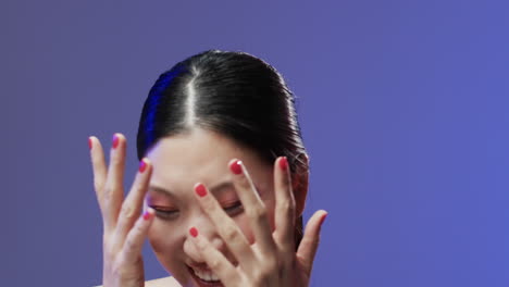 Asian-woman-with-black-hair-and-make-up-covering-her-face,-copy-space,-slow-motion