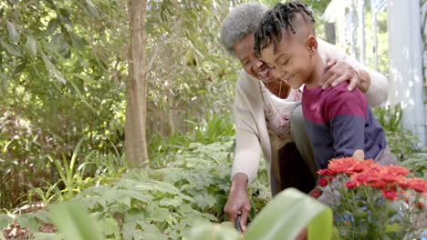 Happy-african-american-mother,-son-and-grandmother-gardening-together,-copy-space,-slow-motion