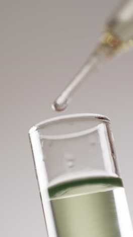 Vertical-video-of-laboratory-pipette-and-test-tube-with-copy-space-on-white-background