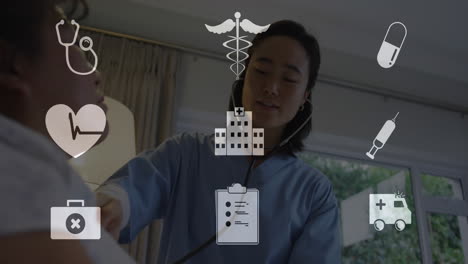 Animation-Digitaler-Symbole-über-Asiatischer-Ärztin-Mit-Patientin-Im-Krankenhaus