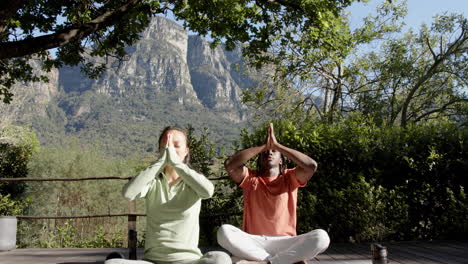 Feliz-Pareja-Diversa-Practicando-Meditación-De-Yoga-Sentada-En-La-Naturaleza-Soleada,-Espacio-Para-Copiar,-Cámara-Lenta