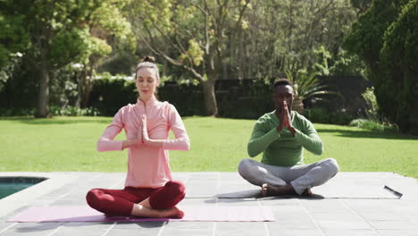 Glückliches,-Vielfältiges-Paar,-Das-Yoga-Im-Sonnigen-Garten-Trainiert,-Zeitlupe