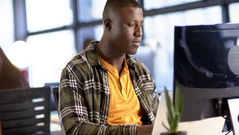 African-american-businessman-using-computer-in-office,-slow-motion,-copy-space