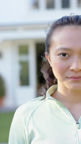 Vertical-video-half-portrait-of-happy-biracial-woman-smiling-in-garden,-slow-motion