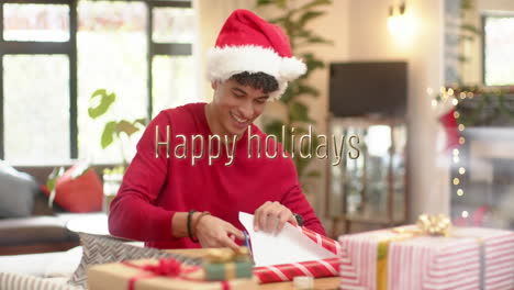Animation-of-happy-holidays-text-over-caucasian-man-wrapping-christmas-presents