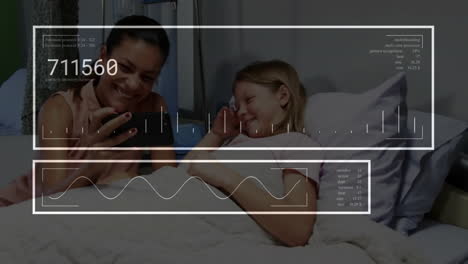 Animation-of-numbers,-graph-over-diverse-mother-showing-video-on-cellphone-to-daughter-in-hospital