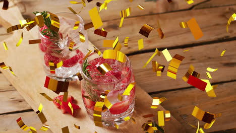 Animation-of-confetti-falling-and-cocktails-on-wooden-background