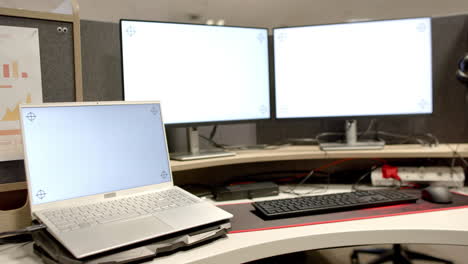 General-view-of-laptop-and-computers-with-blank-screens-in-office,-slow-motion