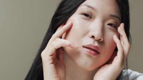 Asian-woman-with-black-hair-and-make-up-touching-face,-copy-space,-slow-motion