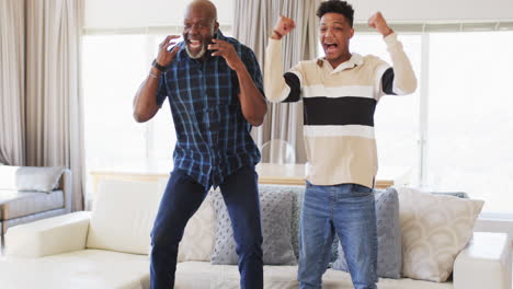 Emocionado-Padre-Afroamericano-E-Hijo-Adulto-Viendo-Deportes-En-Televisión-Y-Celebrando,-Cámara-Lenta