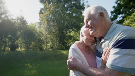Happy-senior-caucasian-couple-embracing-in-sunny-garden,-slow-motion,-copy-space
