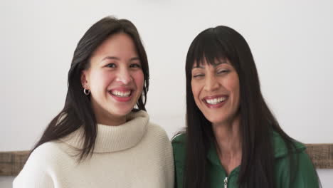 Portrait-of-happy-biracial-mother-and-adult-daughter-smiling-together-at-home,-slow-motion