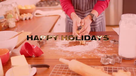 Animation-of-happy-holidays-text-over-caucasian-man-baking-in-kitchen