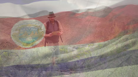 Animation-of-costa-rica-flag-waving-over-caucasian-man-with-map-walking-in-mountains